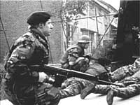 Image of soldiers crouched down on the ground taking cover