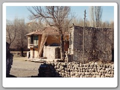 Modern home with old brick house next to it and a satellite dish